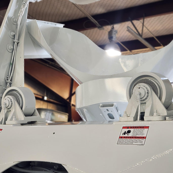 Mechanic working on a putzmiester concrete pump truck in a western mixer service bay